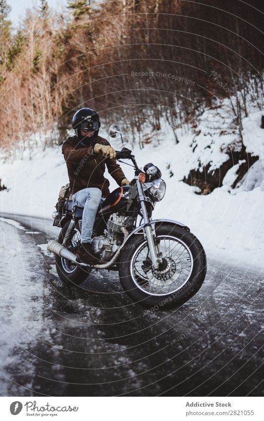 Man riding motorcycle on snowy road Motorcycle Nature Wanderlust Snow Winter Posture traveler Self-confident Forest Street Transport Remote Landscape