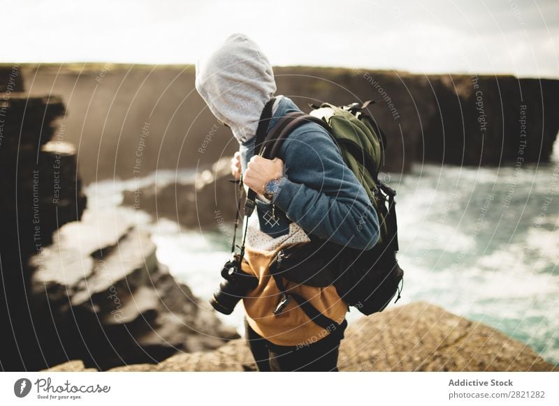 Traveler with photo camera on nature Man Photographer Backpacking Nature Professional traveler Photography Vacation & Travel Tourism Ocean Camera Adventure