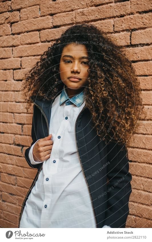 Stylish woman at brick wall Woman pretty Beautiful Ethnic Black Curly African Youth (Young adults) Stand Wall (building) Brick Street Brunette Attractive