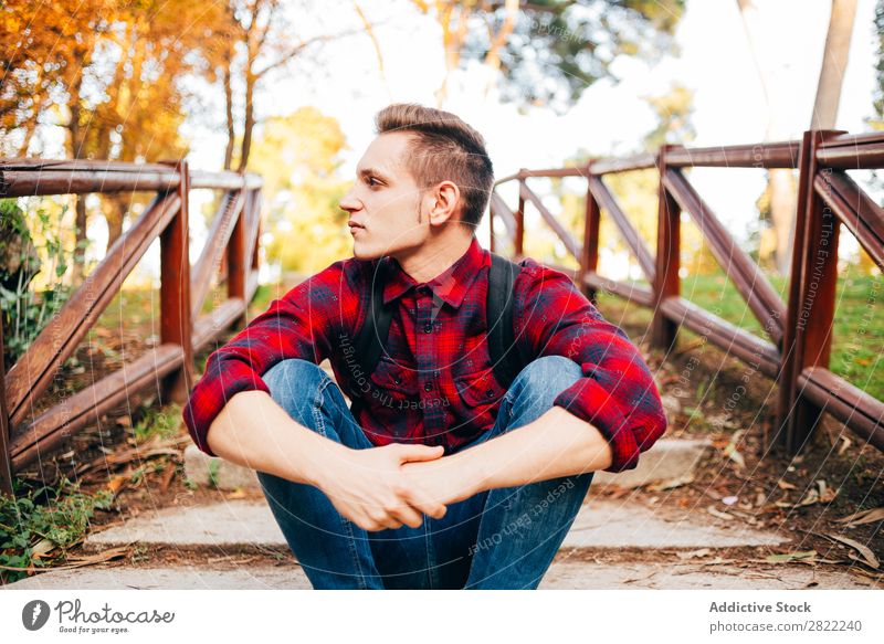 Young man sitting on steps Man Park Sit Considerate Pensive Steps Corridor Nature Human being Lifestyle Grass Leisure and hobbies Easygoing Youth (Young adults)