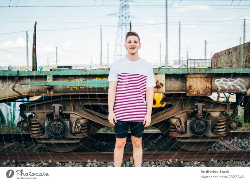 Cheerful man standing at train Man Railroad Town Stand Vacation & Travel Transport Human being Station City Youth (Young adults) Lifestyle Trip Platform Tourist