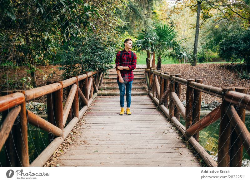 Young man standing on bridge Man Park Considerate Pensive Steps Corridor Nature Human being Lifestyle Grass Leisure and hobbies Easygoing Youth (Young adults)