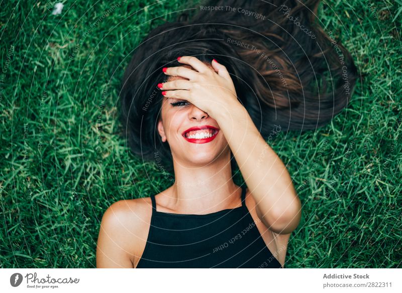Cheerful brunette woman lying in grass Woman pretty Youth (Young adults) Beautiful Smiling Lie (Untruth) Grass Nature Looking into the camera Brunette