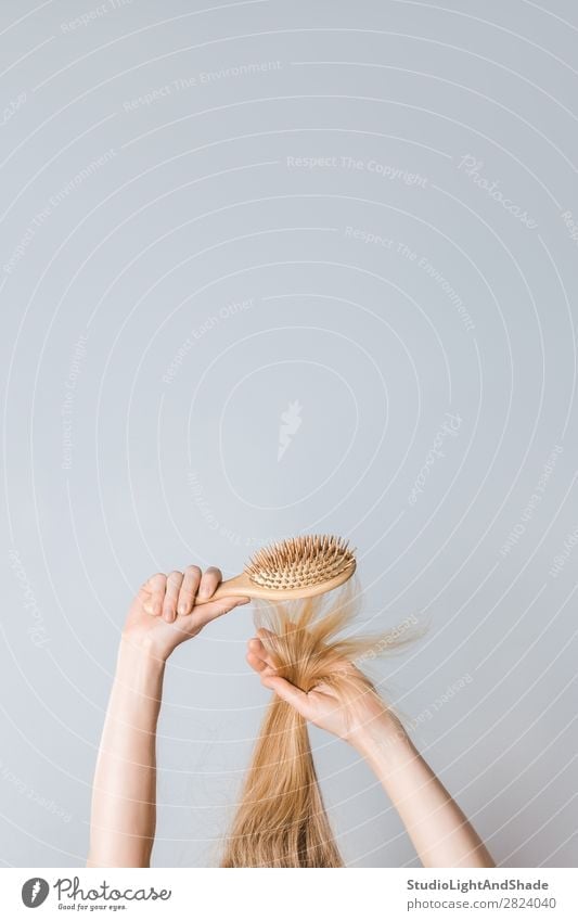 Brushing blond hair with a wooden hairbrush Lifestyle Beautiful Hair and hairstyles Health care Human being Woman Adults Arm Hand Fashion Blonde Hairbrush Wood