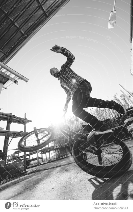 BMX rider performing tricks BMX bike Man Jump Bicycle Sports Trick Youth (Young adults) Lifestyle in motion Action Extreme Black & white photo Rider