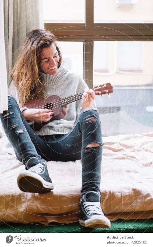 Cheerful woman playing ukulele Woman Home Relaxation Ukulele Playing Lifestyle Musician Smiling Beautiful Room Human being Easygoing Adults