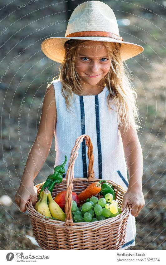 Expressive kid with fruit in basket Girl Basket Posture Summer Harvest Fruit Vegetable Style Excitement Rural Agriculture Landscape Nature Picnic vitamins