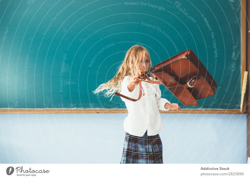 Girl throwing backpack in classroom - a Royalty Free Stock Photo from  Photocase
