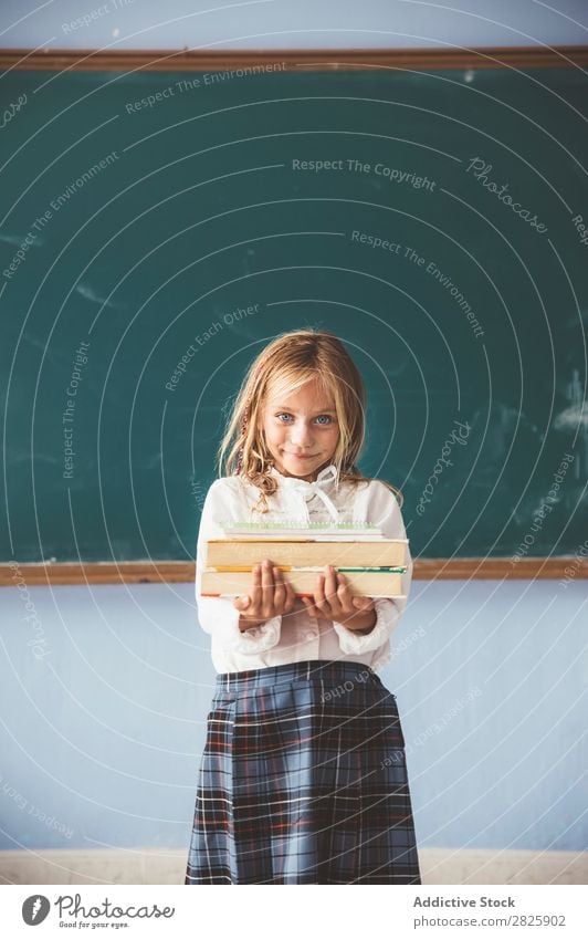 Pupil at chalkboard with books in hand Girl Classroom Blackboard Stand Cheerful Happy Smiling Book Chalk Cute Education School Grade (school level) Student
