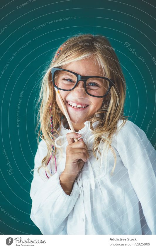 Cute schoolgirl with pencil Girl Classroom Blackboard Person wearing glasses Pencil Looking into the camera Smiling Cheerful Stand Education School