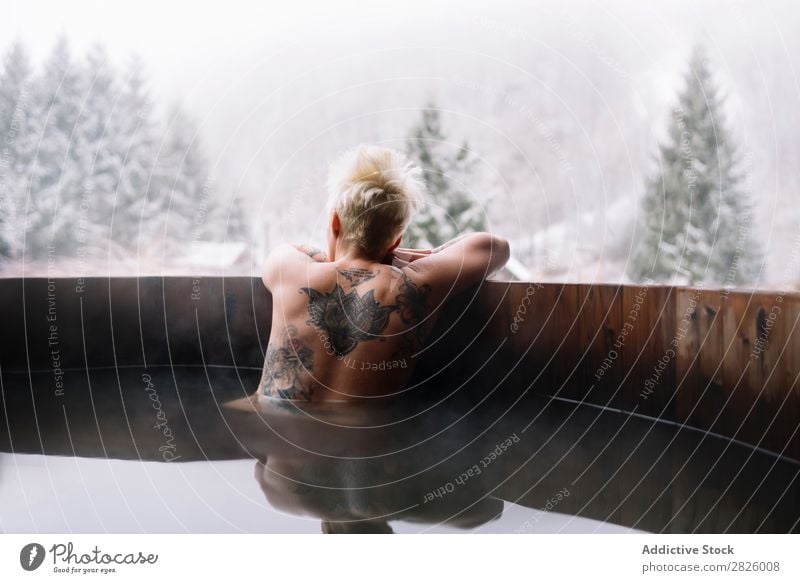 Tattooed blonde woman swimming in plunge tub Woman Swimming Nature Winter topless Water Healthy Beautiful Vacation & Travel Romania Float in the water Blonde