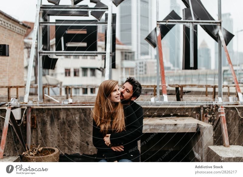 Beautiful couple sitting on rooftop Couple Cheerful Embrace City Love Sit Skyline Architecture love story Town Joy Together Happy Youth (Young adults) 2