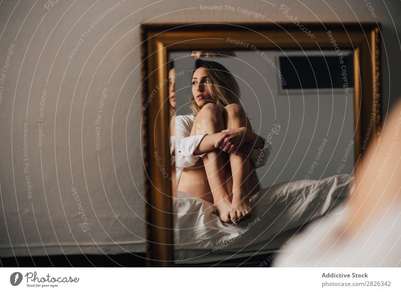 Woman hugging her knees embracing Reflection Mirror Looking away Bed Morning Home Pensive sleepy Considerate Attractive Beautiful Resting Lifestyle Human being