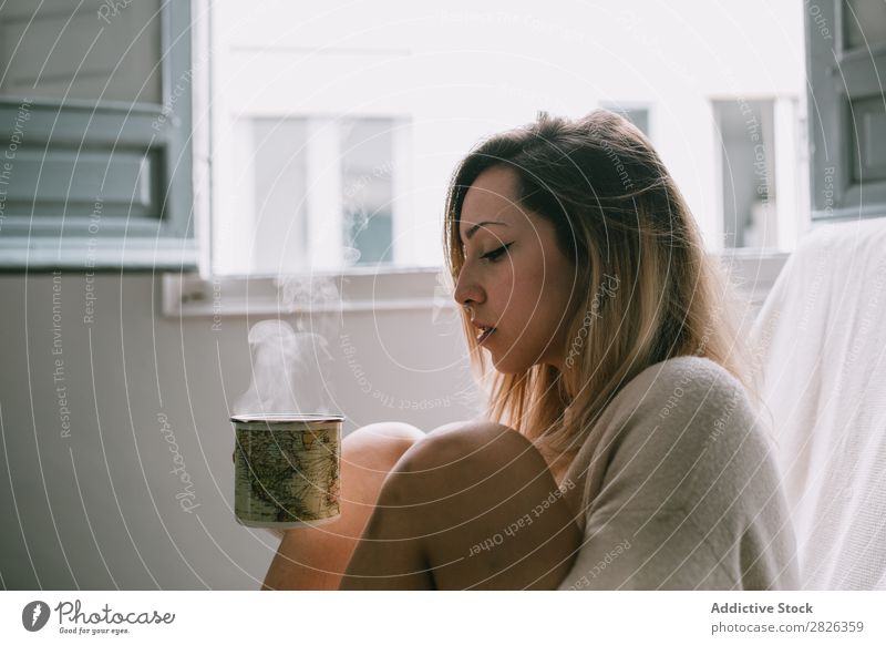 Woman having a hot drink Hot Drinking Cup Morning Beverage knees Embrace Youth (Young adults) Home Pensive Considerate Attractive Beautiful Resting Lifestyle