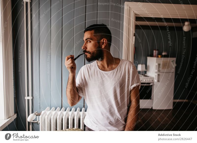 Man smoking pipe inside - a Royalty Free Stock Photo from Photocase