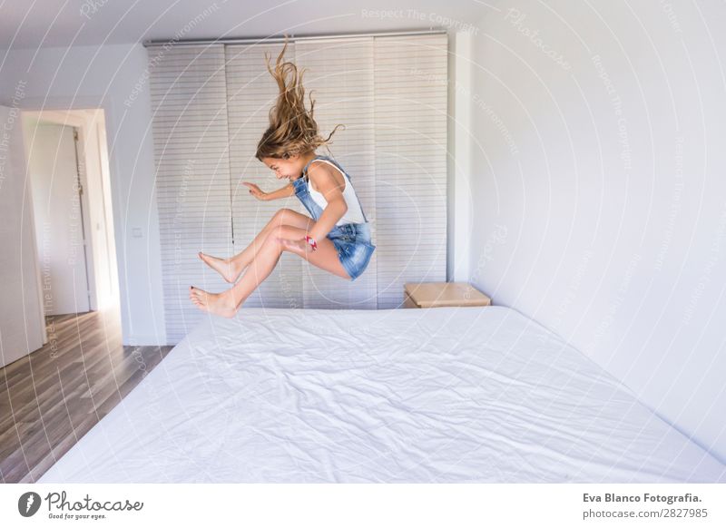 beautiful kid girl playing and jumping on bed Lifestyle Joy Happy Beautiful Leisure and hobbies Playing Reading Summer Bedroom Child Human being Feminine