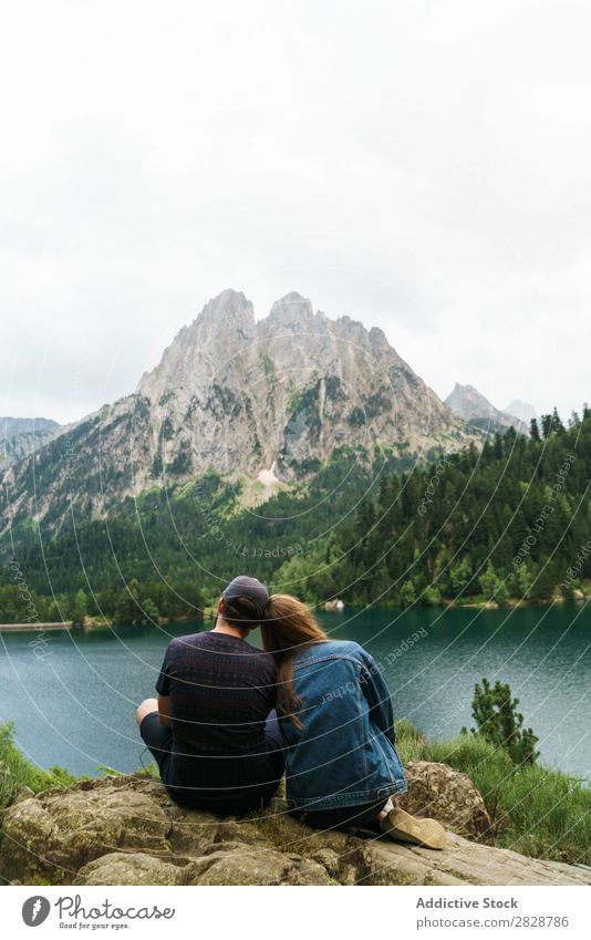 Friends sitting at lake in mountains Woman Man Mountain Together Joy Hiking Lake Water embracing Happy Vacation & Travel Adventure Tourist Youth (Young adults)