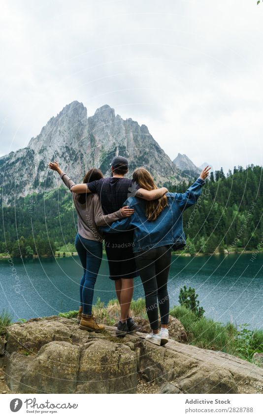 Friends at lake in mountains together Woman Man Mountain Together Stand Joy Hiking Lake Water embracing Happy Vacation & Travel Adventure Tourist