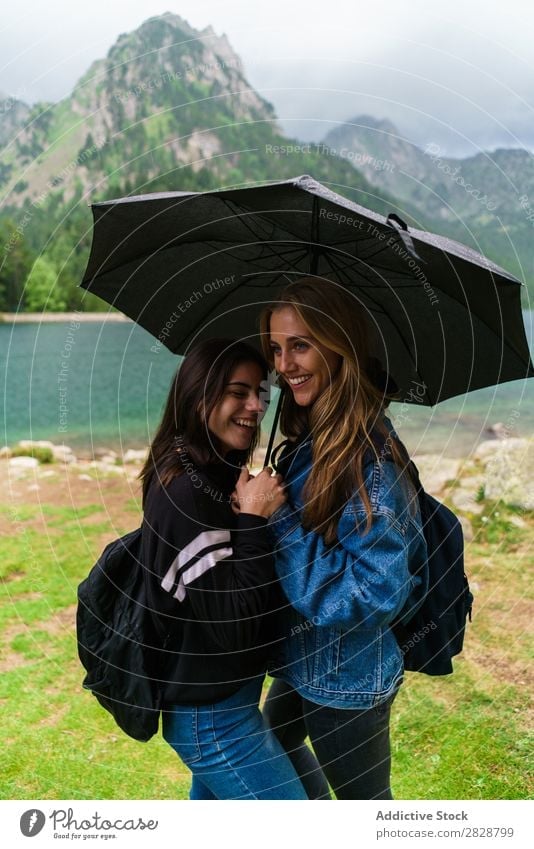 Women under umbrella in mountains Woman Mountain Together Stand Smiling Hiking Lake Water Umbrella Rain Cheerful Happy Vacation & Travel Adventure Tourist