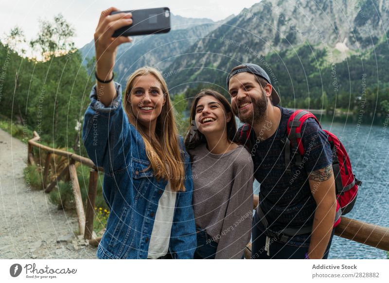 Friends taking selfie in mountains Woman Man Mountain Walking Selfie PDA Take Together Smiling Hiking Lake Water embracing Cheerful Happy Vacation & Travel