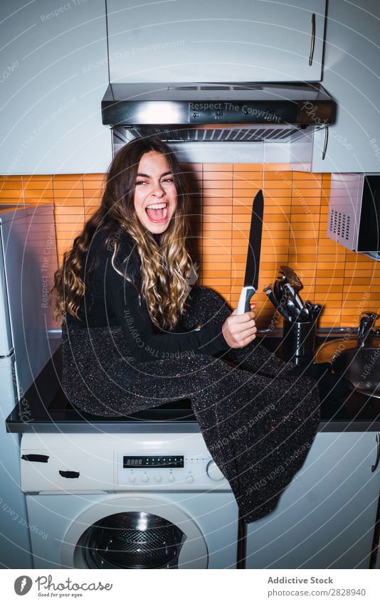 Expressive woman posing with knife Woman pretty Posture Knives Sit Table Dangerous Home Kitchen Beautiful Lifestyle Youth (Young adults) Human being Happy