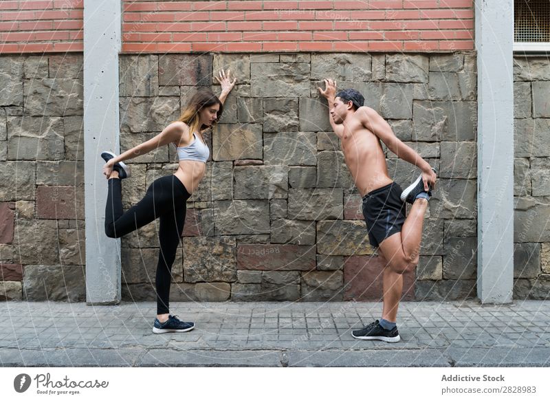 Couple stretching on street sportsmen Stretching Town Fitness Sportswear workout Athletic City Healthy Strong Action flexibility Youth (Young adults)