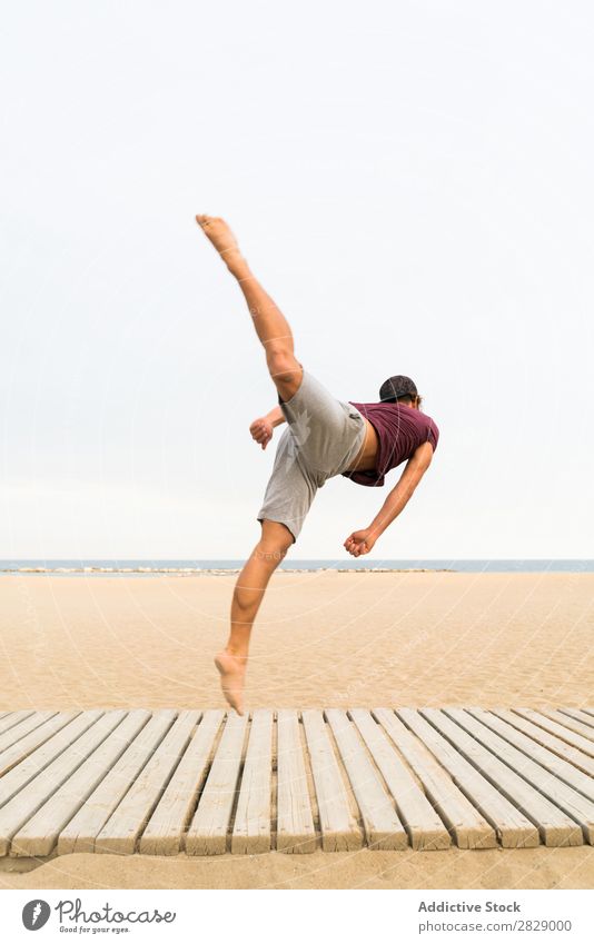 Man practicing jumps on beach Jump Beach Sports flip Practice Fitness Freedom Balance pose Power Energy Athlete Easygoing Sunset workout Muscular Exterior shot