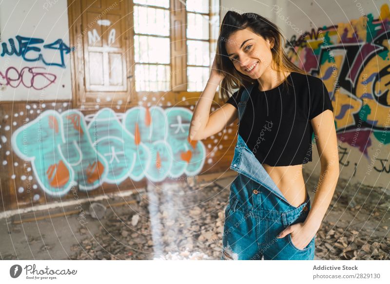 Woman posing in abandoned building Building Smiling Cheerful Posture Graffiti Attractive To enjoy Hair Set Youth (Young adults) Portrait photograph Beautiful