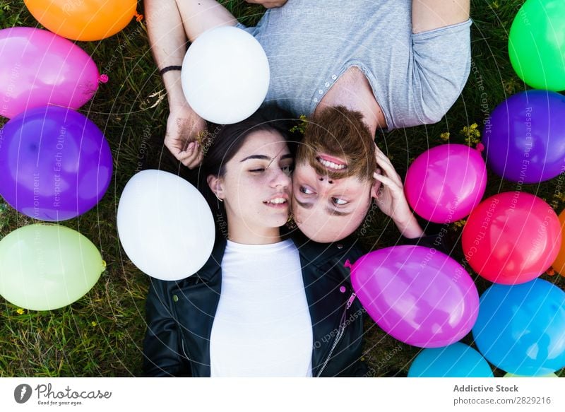 Couple having fun in balloons Woman Man Together covering face Smiling Love Nature Friendship Human being pretty handsome bearded Posture Freedom Joy Beautiful