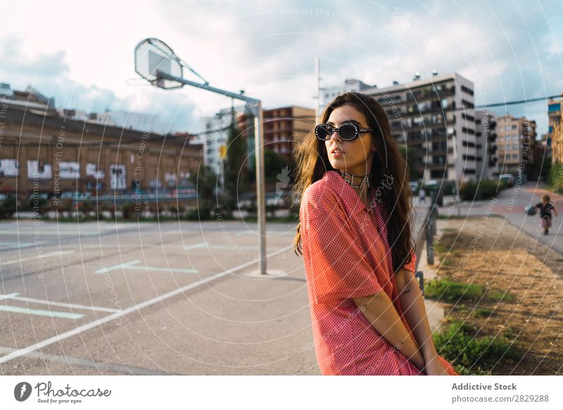 Woman sitting in a fence at playground Style Street Fence Playground Town Posture Sunglasses Portrait photograph Attractive Beauty Photography Hip & trendy