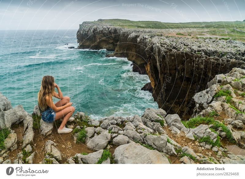 Woman sitting on cliff Cliff Ocean Sit Beautiful Rock Summer Nature Vacation & Travel Water Landscape Youth (Young adults) Blue Lifestyle Freedom Hiking Top