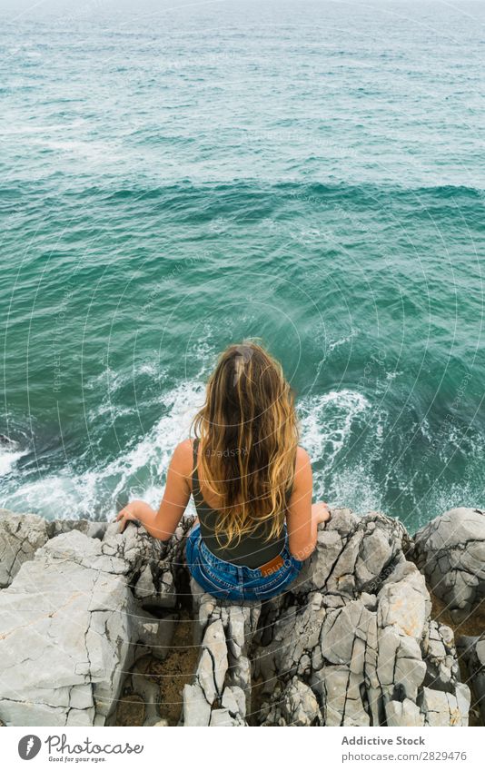 Woman sitting at edge of rock Cliff Ocean Sit Beautiful Rock Summer Nature Vacation & Travel Water Landscape Youth (Young adults) Blue Lifestyle Freedom Hiking