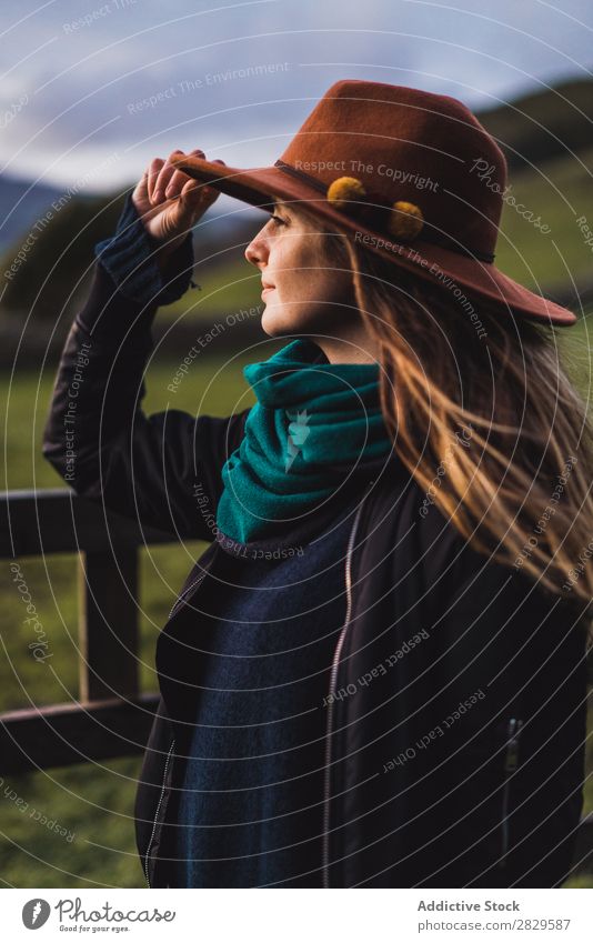 Dreamy woman standing at fence on field Woman Sit Field Green Nature Meadow Fence Stand Relaxation Rest Looking away Hat Spring Summer Grass Landscape