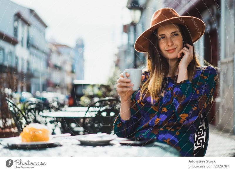 Woman with cup and smartphone in outside cafe pretty Style Street Hat Coffee Cup Café Exterior shot Fashion Beautiful Youth (Young adults) Portrait photograph