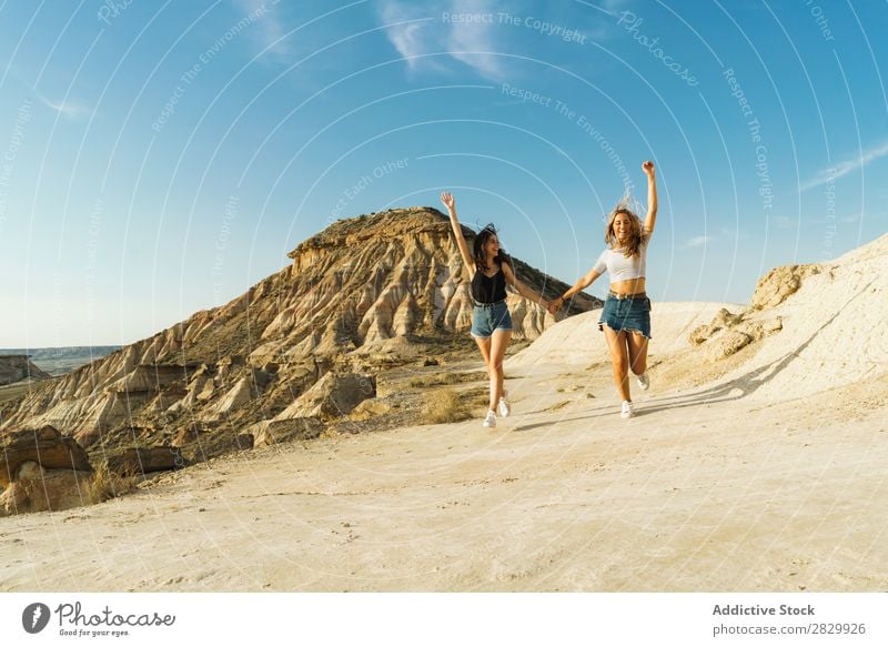 Happy women walking on hill Woman Cliff Excitement Running holding hands Freedom Vacation & Travel Success Top Mountain Youth (Young adults) Nature Rock