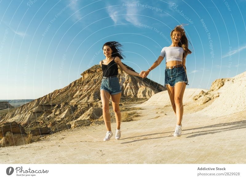 Happy women walking on hill Woman Cliff Excitement Running holding hands Freedom Vacation & Travel Success Top Mountain Youth (Young adults) Nature Rock