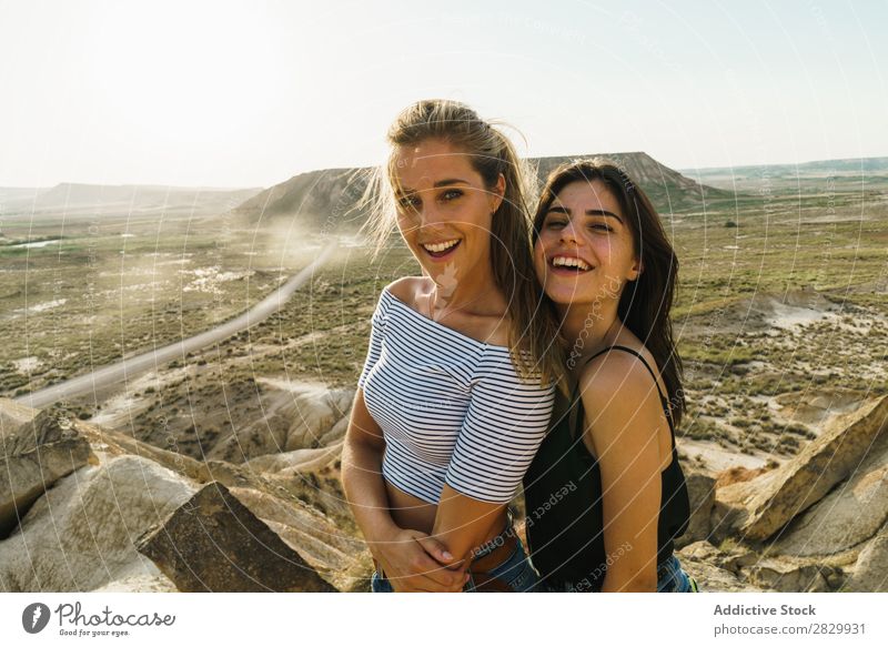 Cheerful women standing on cliff Woman Cliff Excitement embracing Looking into the camera Smiling Embrace Freedom Vacation & Travel Success Top Mountain