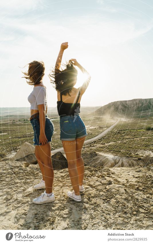 Cheerful women standing on cliff Woman Cliff Excitement Embrace Freedom Vacation & Travel Success Top Mountain Youth (Young adults) Nature Rock Landscape Happy