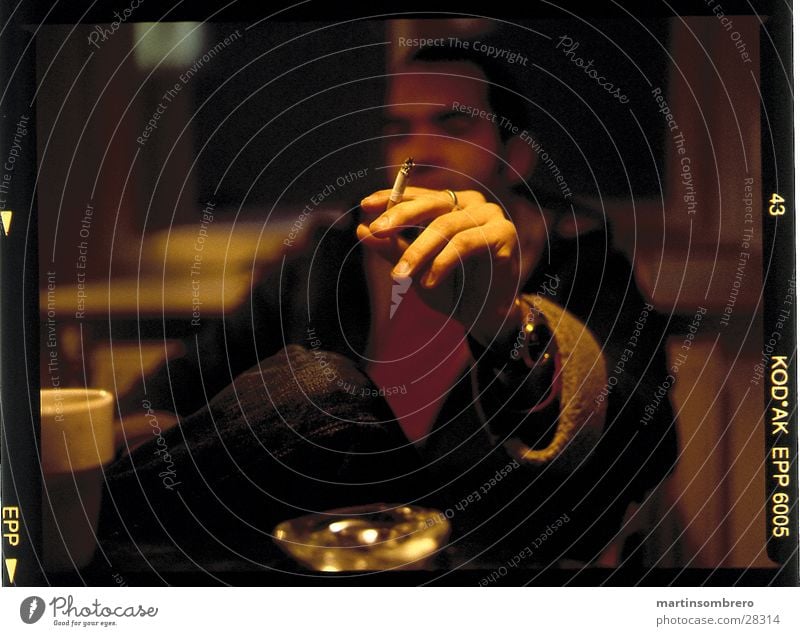 smoke Ashtray Cozy Man hand holding a cigarette depth blur Smoking Evening Interior shot