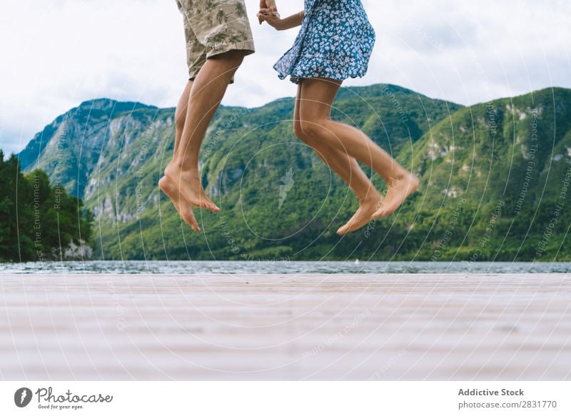 Crop couple posing on pier Couple Jetty Joy Lake Mountain Jump Happy Love Together Nature Summer Water Youth (Young adults) Woman Vacation & Travel Lifestyle