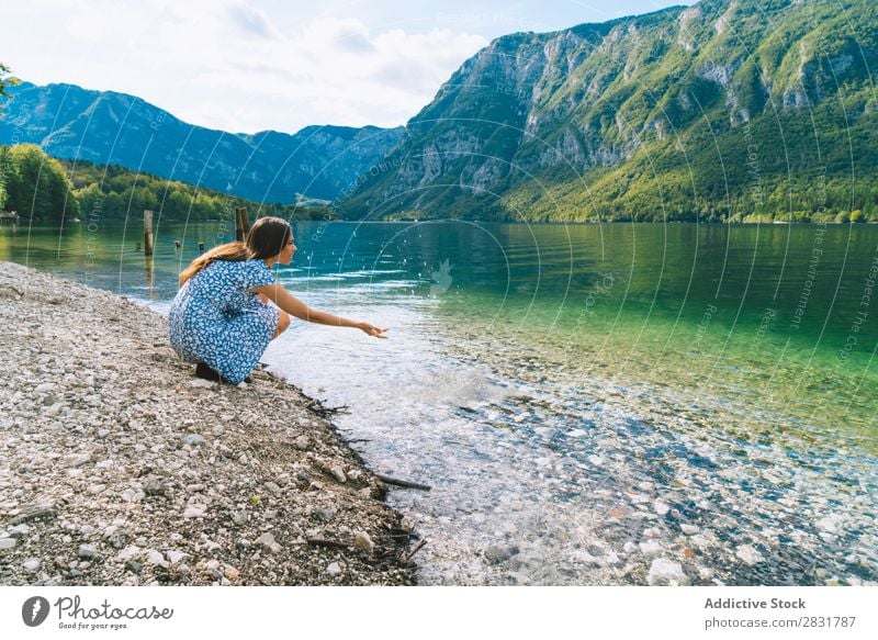 Woman sitting at lake Lake Hand pulling Coast Sit Mountain Nature Summer Water Youth (Young adults) Vacation & Travel Lifestyle Human being Beautiful Landscape
