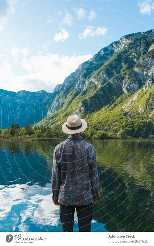 Man standing at lake Lake Stand Mountain Water Nature Landscape Human being Tourism Hiking Loneliness Calm Tourist Rock scenery Relaxation Freedom