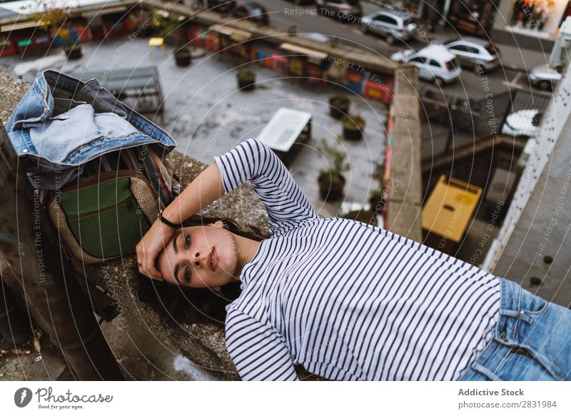 Woman lying on building edge City Tourist Backpack Lie (Untruth) Building Edge Beautiful Vacation & Travel Street Looking into the camera Youth (Young adults)