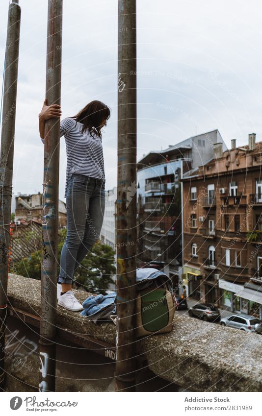 Woman standing on concrete fence Human being Town Grunge Posture Fence Expression Youth (Young adults) Modern Style Street Self-confident pose Stand
