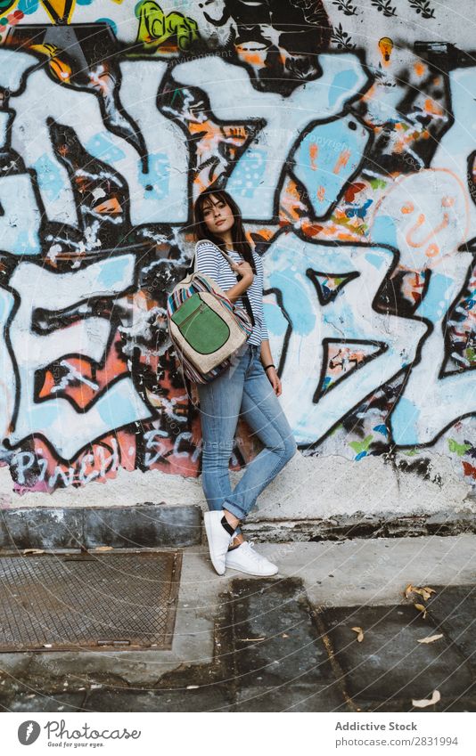 Confident woman posing at street Human being Easygoing Posture Self-confident Style Accessory Backpack Traveling Graffiti Pavement Town Beauty Photography