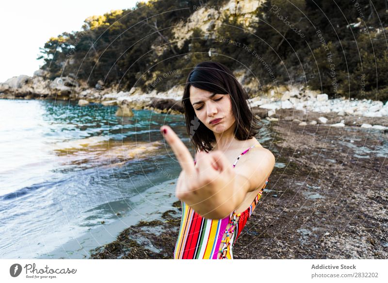 Expressive girl on beach showing middle finger Woman Beach Gesture provocation Aggressive Summer abusive Emotions Youth (Young adults) Vacation & Travel