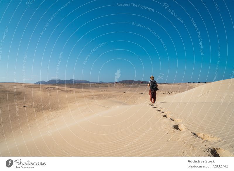Anonymous man walking on sand hills Man Sand Dune Walking Adventure Desert exploration Sun Traveling footsteps Vacation & Travel Horizon traveler Wilderness