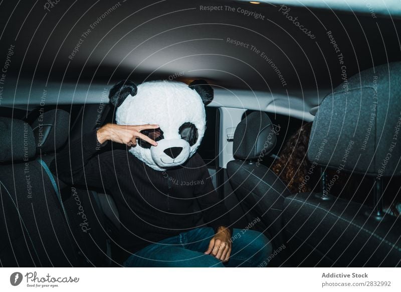 Man in panda mask Mask Peace Gesture two fingers Human being Panda Indicate Back Seat Passenger compartment Car Vehicle Transport Hand Success