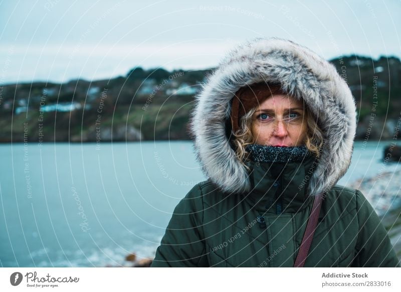 Tourist woman at seaside traveler Coast Woman Looking into the camera warm clothes Vacation & Travel Tourism Trip Rock Ocean Landscape Beach Nature Water