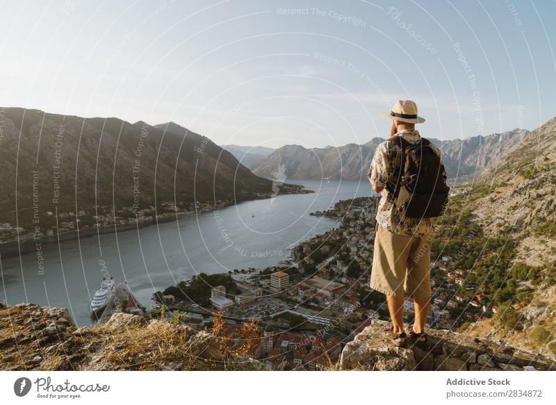Tourist looking at riverside town Town Mountain River Man Human being Village Vantage point pathway Landscape Vacation & Travel Nature Tourism Beautiful Valley